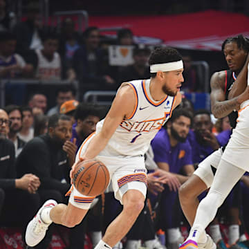 Apr 10, 2024; Los Angeles, California, USA; Phoenix Suns guard Devin Booker (1) moves the ball as forward Kevin Durant (35) provides coverage against Los Angeles Clippers guard Bones Hyland (5) during the first half at Crypto.com Arena. Mandatory Credit: Gary A. Vasquez-Imagn Images