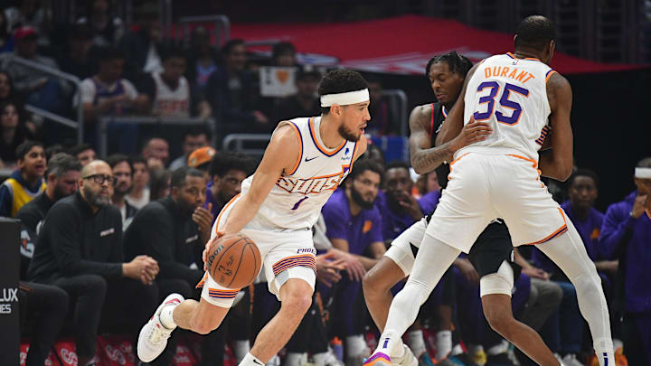 Apr 10, 2024; Los Angeles, California, USA; Phoenix Suns guard Devin Booker (1) moves the ball as forward Kevin Durant (35) provides coverage against Los Angeles Clippers guard Bones Hyland (5) during the first half at Crypto.com Arena. Mandatory Credit: Gary A. Vasquez-Imagn Images