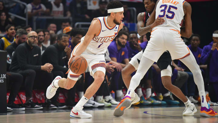 Apr 10, 2024; Los Angeles, California, USA; Phoenix Suns guard Devin Booker (1) moves the ball as forward Kevin Durant (35) provides coverage against Los Angeles Clippers guard Bones Hyland (5) during the first half at Crypto.com Arena. Mandatory Credit: Gary A. Vasquez-USA TODAY Sports