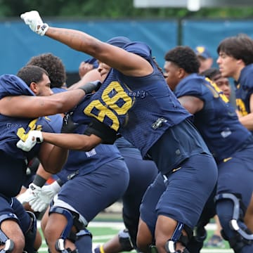 West Virginia University defensive lineman Devin Grant (91) locks up with defensive lineman Brandon Caesar (98)