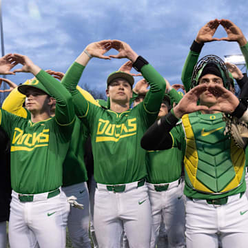 Oregon baseball players flash the “O” to fans after the Ducks beat the Toledo Rockets in their home opener at PK Park in Eugene Friday, Feb. 14, 2025.