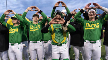 Oregon baseball players flash the “O” to fans after the Ducks beat the Toledo Rockets in their home opener at PK Park in Eugene Friday, Feb. 14, 2025.