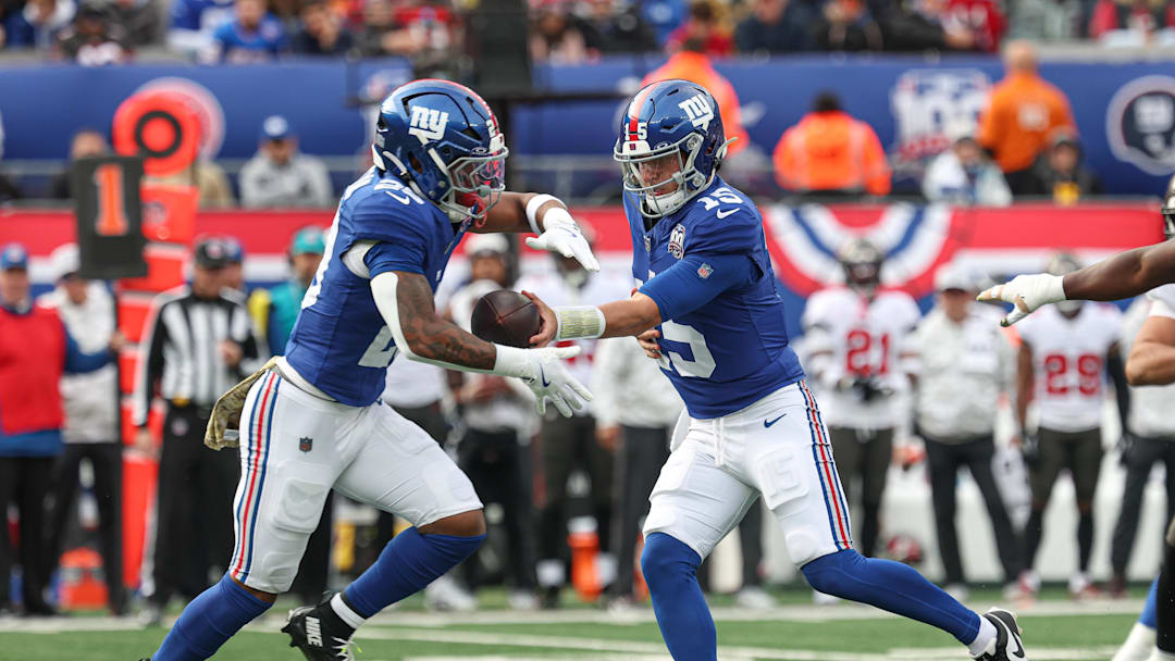 Nov 24, 2024; East Rutherford, New Jersey, USA; New York Giants quarterback Tommy DeVito (15) hands off to running back Tyrone Tracy Jr. (29) during the first half against the Tampa Bay Buccaneers at MetLife Stadium.  