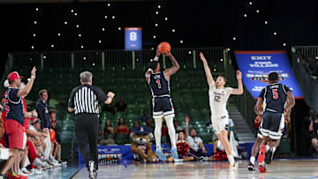 Nov 29, 2024; Paradise Island, Bahamas, BHS;  Arizona Wildcats guard Caleb Love (1) scores over West Virginia Mountaineers guard Tucker DeVries (12) during the second half at Imperial Arena at the Atlantis resort.  Mandatory Credit: Kevin Jairaj-Imagn Images