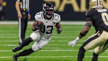 Aug 17, 2025; New Orleans, Louisiana, USA;  Jacksonville Jaguars running back Bhayshul Tuten (33) runs against New Orleans Saints safety Ugo Amadi (0) during the first half at Caesars Superdome. Mandatory Credit: Stephen Lew-Imagn Images