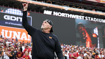 Sep 21, 2025; Landover, Maryland, USA; Washington Commanders head coach Dan Quinn waves while walking onto the field prior to the Commanders' game against the Las Vegas Raiders at Northwest Stadium. Mandatory Credit: Geoff Burke-Imagn Images