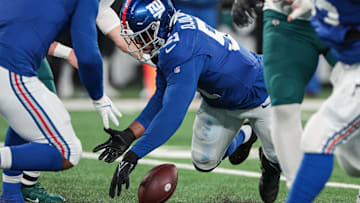 Jan 7, 2024; East Rutherford, New Jersey, USA; New York Giants linebacker Azeez Ojulari (51) recovers a fumble by Philadelphia Eagles quarterback Marcus Mariota (not pictured) during the second half at MetLife Stadium. Mandatory Credit: Vincent Carchietta-Imagn Images