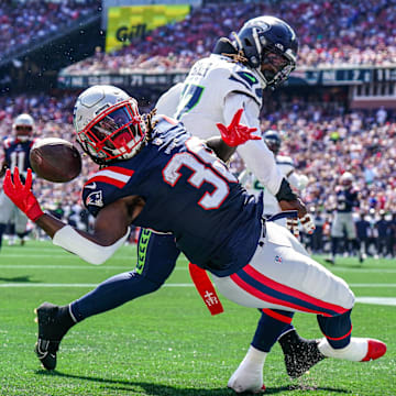 Sep 15, 2024; Foxborough, Massachusetts, USA; New England Patriots running back Rhamondre Stevenson (38) misses the pass against Seattle Seahawks linebacker Jerome Baker (17) in the second quarter at Gillette Stadium. Mandatory Credit: David Butler II-Imagn Images