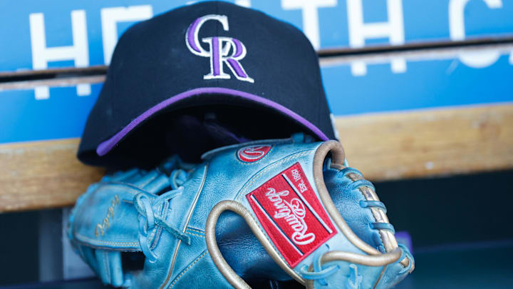 Colorado Rockies cap and glove in the dugout. 