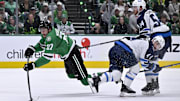 May 11, 2025; Dallas, Texas, USA; Dallas Stars left wing Mason Marchment (27) is tripped up as he shoots the puck past Winnipeg Jets defenseman Neal Pionk (4) and defenseman Dylan Samberg (54) during the second period in game three of the second round of the 2025 Stanley Cup Playoffs at American Airlines Center. Mandatory Credit: Jerome Miron-Imagn Images