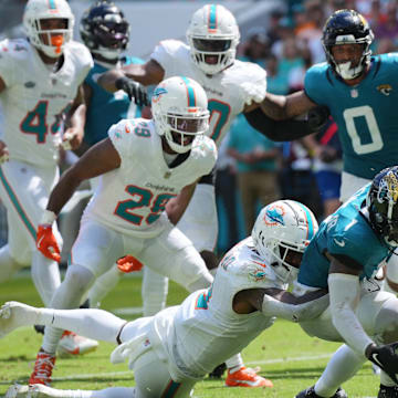 Miami Dolphins safety Jevon Holland (8) punches the ball away from Jacksonville Jaguars running back Travis Etienne Jr. (1) causing a fumble that was recovered by the Dolphins in the end zone during the third quarter at Hard Rock Stadium.