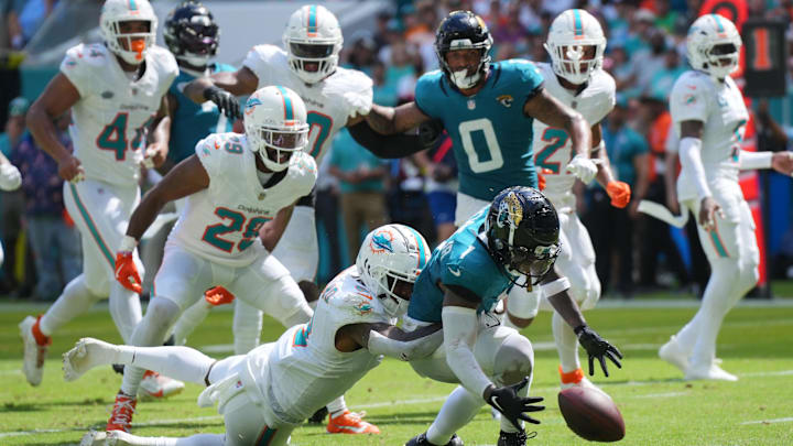 Miami Dolphins safety Jevon Holland (8) punches the ball away from Jacksonville Jaguars running back Travis Etienne Jr. (1) causing a fumble that was recovered by the Dolphins in the end zone during the third quarter at Hard Rock Stadium.