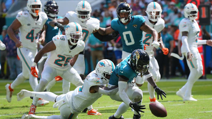 Miami Dolphins safety Jevon Holland (8) punches the ball away from Jacksonville Jaguars running back Travis Etienne Jr. (1) causing a fumble that was recovered by the Dolphins in the end zone during the third quarter at Hard Rock Stadium.