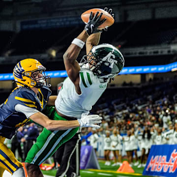Detroit Cass Tech WR Corey Sadler Jr. catches a touchdown pass, while being covered by Hudsonville Ty Ykema in the second quarter, during the MHSAA Division 1 football finals at Ford Field in Detroit on Saturday, Nov. 30, 2024.