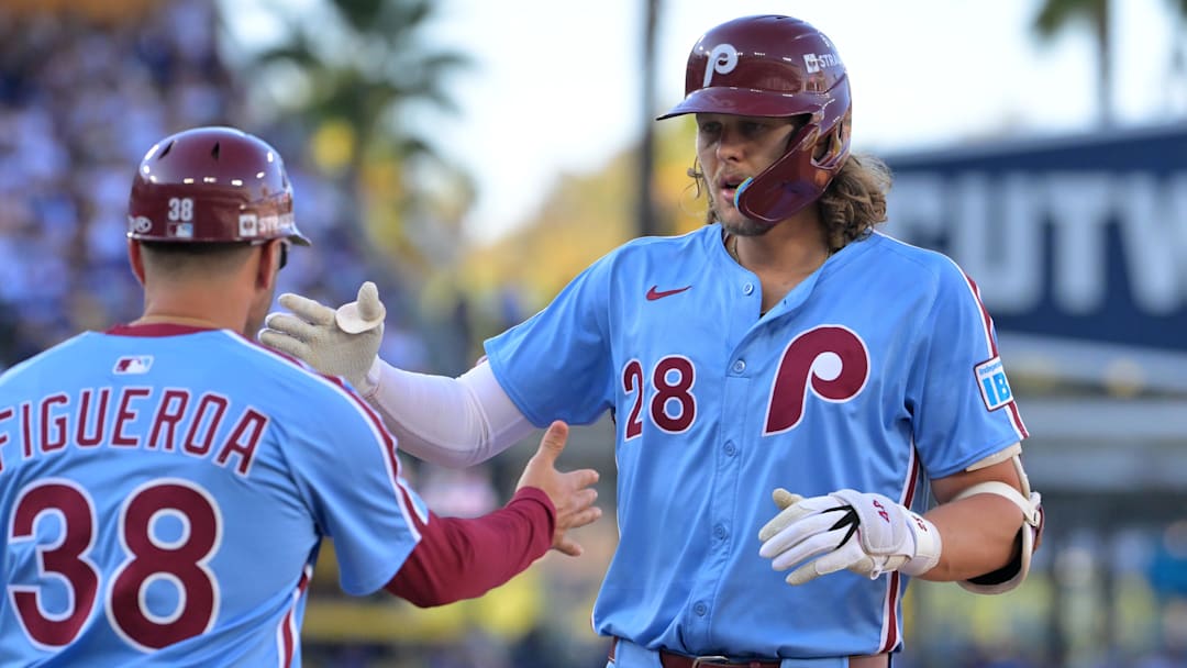 Oct 9, 2025; Los Angeles, California, USA; Philadelphia Phillies third baseman Alec Bohm (28) celebrates with Philadelphia Phillies first base coach Paco Figueroa (38) after a single in the sixth inning during game four of the NLDS round for the 2025 MLB playoffs at Dodger Stadium. Mandatory Credit: Jayne Kamin-Oncea-Imagn Images