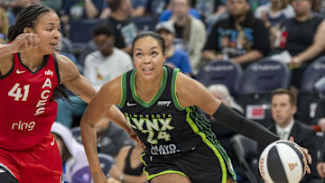 Jun 17, 2025; Minneapolis, Minnesota, USA; Minnesota Lynx forward Napheesa Collier (24) dribbles the ball past Las Vegas Aces center Kiah Stokes (41) in the second half at Target Center. Mandatory Credit: Jesse Johnson-Imagn Images