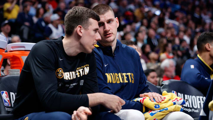 Apr 19, 2023; Denver, Colorado, USA; Denver Nuggets center Nikola Jokic (15) talks with forward Vlatko Cancar (31) on the bench while keeping a heating pad on his wrist in the fourth quarter against the Minnesota Timberwolves during game two of the 2023 NBA Playoffs at Ball Arena. Mandatory Credit: Isaiah J. Downing-USA TODAY Sports