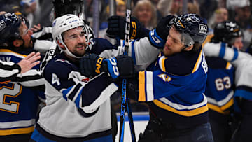 May 2, 2025; St. Louis, Missouri, USA; Winnipeg Jets defenseman Neal Pionk (4) and St. Louis Blues defenseman Philip Broberg (6) get physical during the third period in game six of the first round of the 2025 Stanley Cup Playoffs at Enterprise Center. Mandatory Credit: Connor Hamilton-Imagn Images
