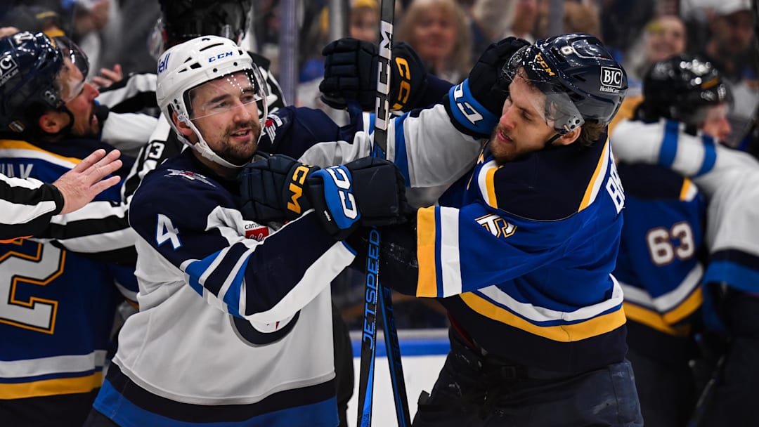 May 2, 2025; St. Louis, Missouri, USA; Winnipeg Jets defenseman Neal Pionk (4) and St. Louis Blues defenseman Philip Broberg (6) get physical during the third period in game six of the first round of the 2025 Stanley Cup Playoffs at Enterprise Center. Mandatory Credit: Connor Hamilton-Imagn Images