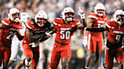 Louisville Cardinals defensive lineman Clev Lubin (50) and teammates Louisville Cardinals defensive back Tayon Holloway (25), left, and Louisville Cardinals defensive lineman Wesley Bailey (23) and Louisville Cardinals linebacker Antonio Watts (9) celebrate creating a turnover on James Madison University as the Cards' beat the visiting Dukes 28-14 Friday September 5, 2025 at L&N Credit Union Stadium in Louisville, Kentucky.