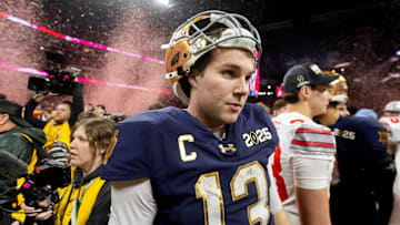 Jan 20, 2025; Atlanta, GA, USA; Confetti falls as Notre Dame Fighting Irish quarterback Riley Leonard (13) walks off the field after losing to the Ohio State Buckeyes in the CFP National Championship college football game at Mercedes-Benz Stadium. 