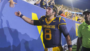 Sep 13, 2025; Morgantown, West Virginia, USA; West Virginia Mountaineers quarterback Nicco Marchiol (8) celebrates with fans after defeating the Pittsburgh Panthers at Milan Puskar Stadium. Mandatory Credit: Ben Queen-Imagn Images