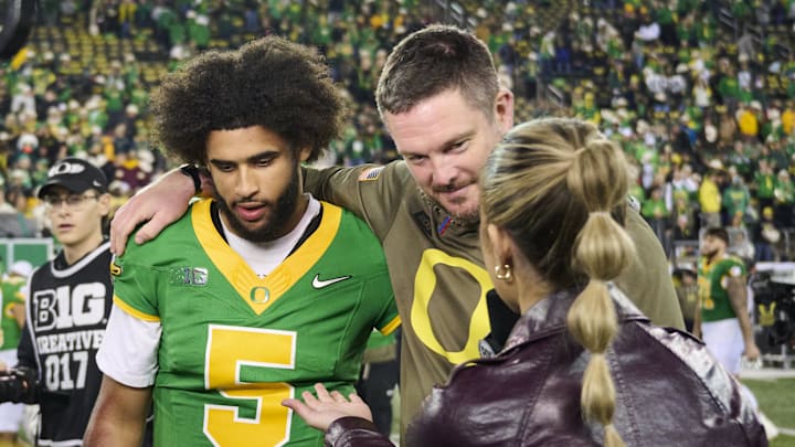 Nov 14, 2025; Eugene, Oregon, USA; Oregon Ducks quarterback Dante Moore (5) and head coach Dan Lanning talk to a reporter after a game against the Minnesota Golden Gophers at Autzen Stadium. Mandatory Credit: Troy Wayrynen-Imagn Images