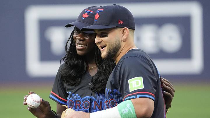 Aug 15, 2025; Toronto, Ontario, CAN; Canadian tennis player Victoria Mboko poses with Toronto Blue Jays designated hitter Bo Bichette (11) after throwing out the first pitch before a game against the Texas Rangers at Rogers Centre. Mandatory Credit: John E. Sokolowski-Imagn Images