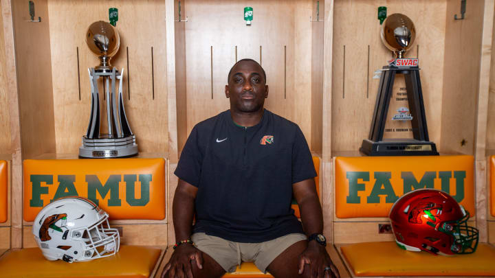 Florida A&M University head football coach James Colzie III poses in the locker room with the championship trophies.