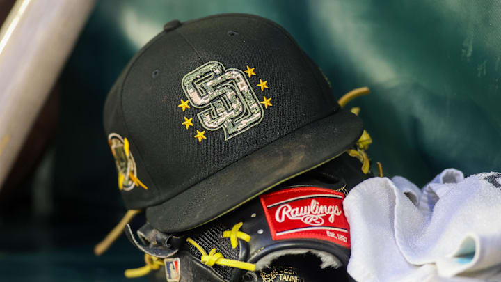 May 17, 2024; Atlanta, Georgia, USA; A detailed view of a San Diego Padres hat and glove on the bench against the Atlanta Braves in the third inning at Truist Park. Mandatory Credit: Brett Davis-Imagn Images