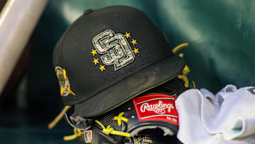 Atlanta, Georgia, USA; A detailed view of a San Diego Padres hat and glove on the bench against the Atlanta Braves in the third inning at Truist Park.
