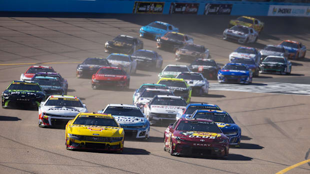 Martin Truex Jr (19) leads Joey Logano (22) at the green flag restart at Phoenix Raceway.