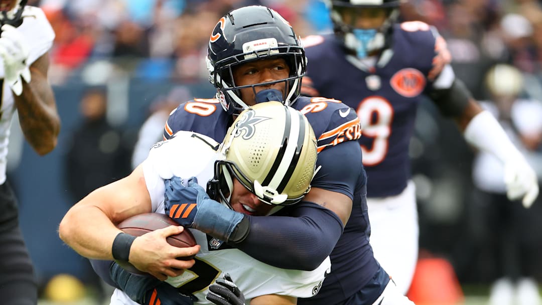 Oct 19, 2025; Chicago, Illinois, USA; Chicago Bears defensive end Dominique Robinson (90) makes a tackle for a loss on New Orleans Saints tight end Taysom Hill (7) during the second quarter at Soldier Field.