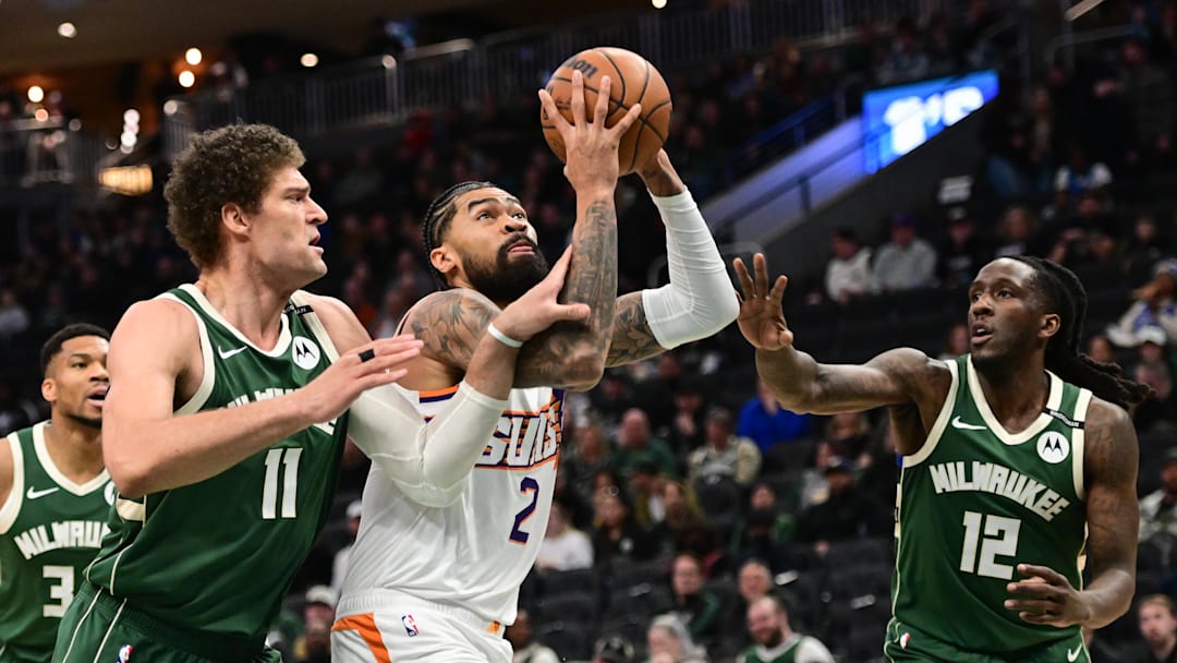 Apr 1, 2025; Milwaukee, Wisconsin, USA;  Phoenix Suns center Nick Richards (2) takes a shot against Milwaukee Bucks center Brook Lopez (11) and guard Taurean Prince (12) in the first quarter at Fiserv Forum. Mandatory Credit: Benny Sieu-Imagn Images