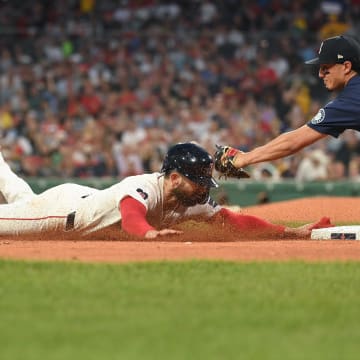 Boston Red Sox catcher Connor Wong (left) is tagged out by Seattle Mariners third baseman Josh Rojas (right) on July 29 at Fenway Park.