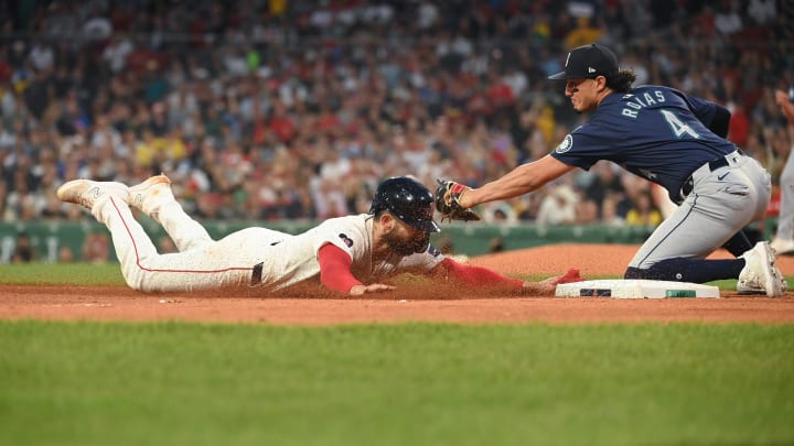 Boston Red Sox catcher Connor Wong (left) is tagged out by Seattle Mariners third baseman Josh Rojas (right) on July 29 at Fenway Park.