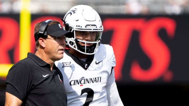 Cincinnati Bearcats head coach Scott Satterfield speaks to Cincinnati Bearcats quarterback Brendan Sorsby (2) in the second quarter of the College Football game between the Cincinnati Bearcats and the Towson Tigers at Nippert Stadium in Cincinnati on Saturday, Aug. 31, 2024.