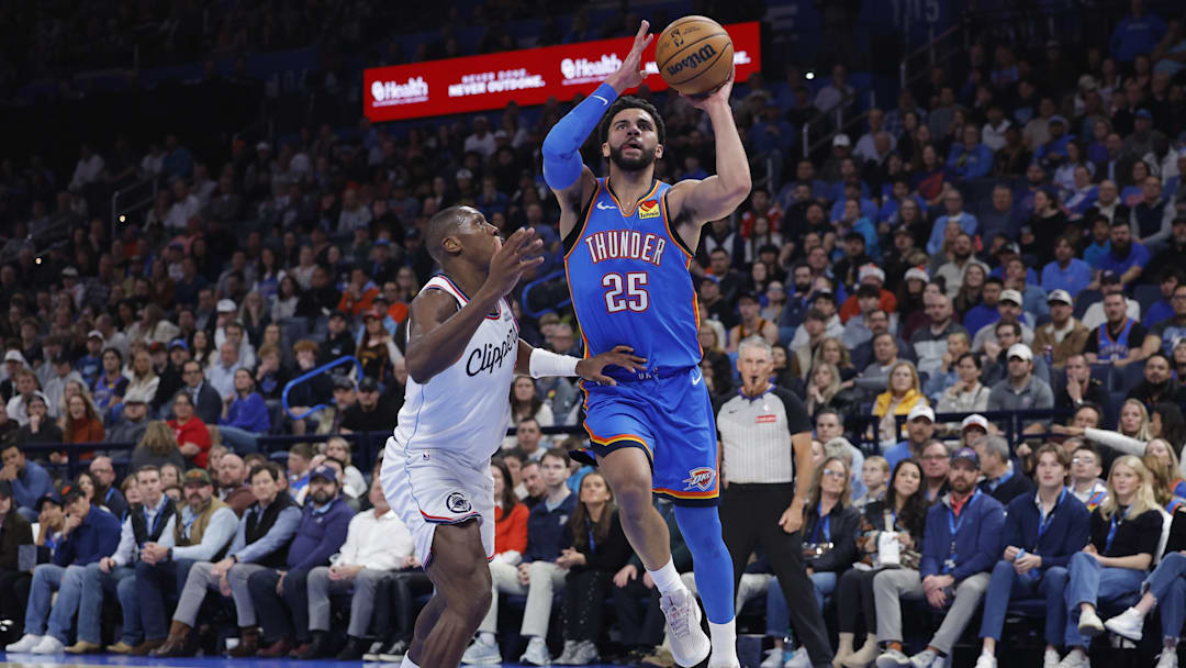 Dec 18, 2025; Oklahoma City, Oklahoma, USA; Oklahoma City Thunder guard Ajay Mitchell (25) drives to the basket beside Los Angeles Clippers guard Kris Dunn (8) during the second quarter at Paycom Center. Mandatory Credit: Alonzo Adams-Imagn Images