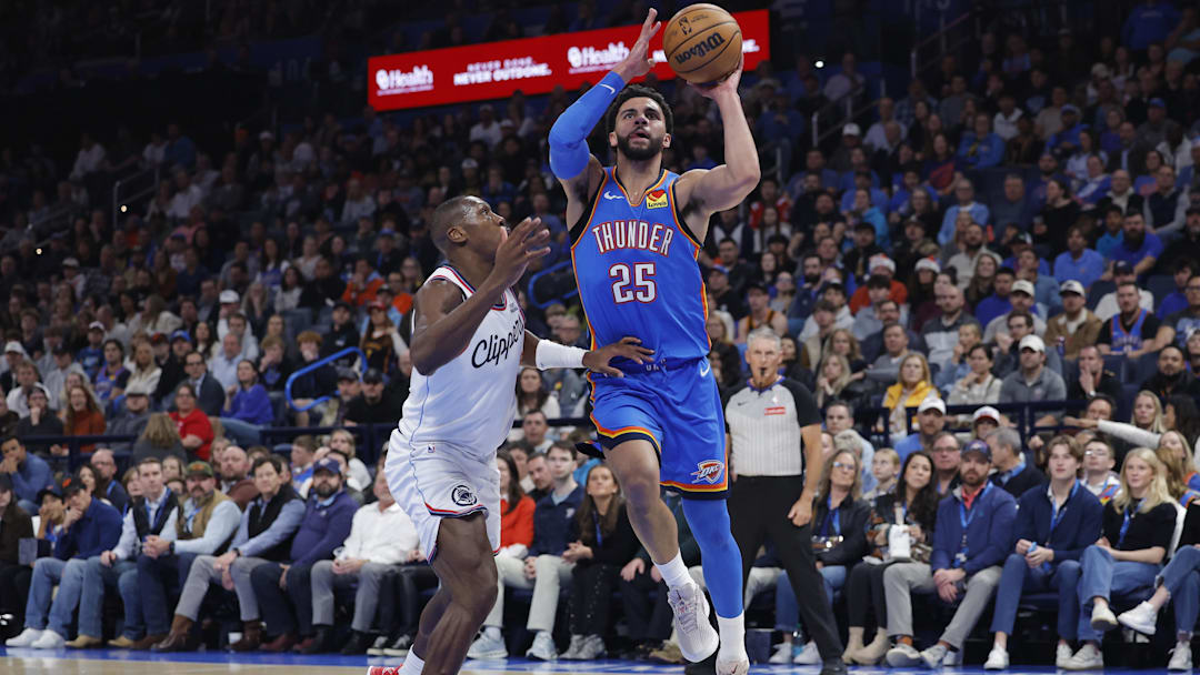 Dec 18, 2025; Oklahoma City, Oklahoma, USA; Oklahoma City Thunder guard Ajay Mitchell (25) drives to the basket beside Los Angeles Clippers guard Kris Dunn (8) during the second quarter at Paycom Center. Mandatory Credit: Alonzo Adams-Imagn Images