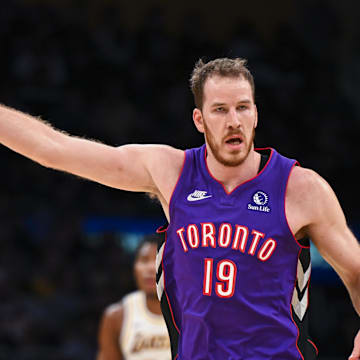 Nov 10, 2024; Los Angeles, California, USA; Toronto Raptors center Jakob Poeltl (19) points against the Los Angeles Lakers during the first half at Crypto.com Arena. Mandatory Credit: Jonathan Hui-Imagn Images