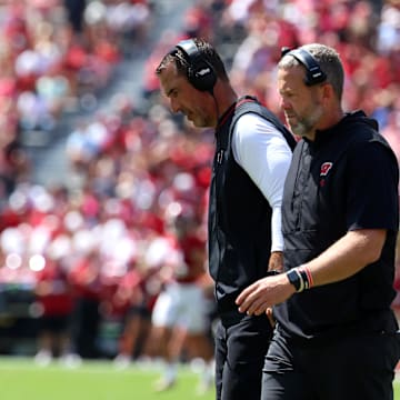 Sep 13, 2025; Tuscaloosa, Alabama, USA; Wisconsin Badgers head coach Luke Fickell converses with an assistant during the second quarter against the Alabama Crimson Tide at Saban Field at Bryant-Denny Stadium. Mandatory Credit: David Leong-Imagn Images