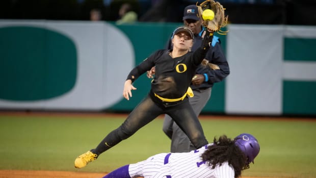 Oregon infielder Paige Sinicki makes a catch as Washington’s Sydney Stewart slides safely into second base as the Oregon Duck