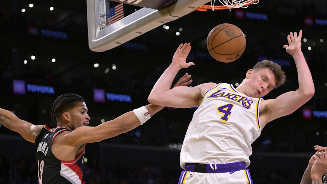 Dec 8, 2024; Los Angeles, California, USA;  Los Angeles Lakers guard Dalton Knecht (4) dunks over Portland Trail Blazers forward Toumani Camara (33) in the second half at Crypto.com Arena. Mandatory Credit: Jayne Kamin-Oncea-Imagn Images