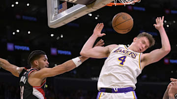 Dec 8, 2024; Los Angeles, California, USA;  Los Angeles Lakers guard Dalton Knecht (4) dunks over Portland Trail Blazers forward Toumani Camara (33) in the second half at Crypto.com Arena. Mandatory Credit: Jayne Kamin-Oncea-Imagn Images