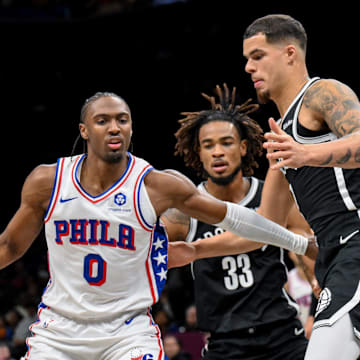 Nov 2, 2025; Brooklyn, New York, USA; Philadelphia 76ers guard Tyrese Maxey (0) sets the play while defended by Brooklyn Nets forward Michael Porter Jr. (17) and center Nic Claxton (33) during the first half at Barclays Center. Mandatory Credit: John Jones-Imagn Images