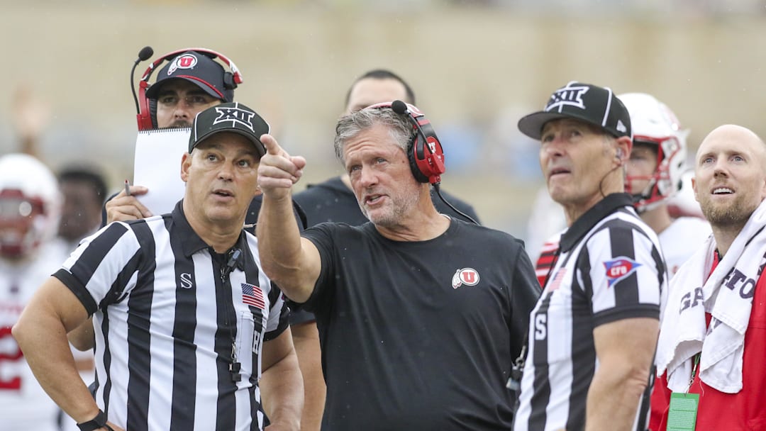 Sep 27, 2025; Morgantown, West Virginia, USA; Utah Utes head coach Kyle Whittingham talks to several officials during the third quarter against the West Virginia Mountaineers at Milan Puskar Stadium. Sep 27, 2025; Morgantown, West Virginia, USA; Utah Utes head coach Kyle Whittingham talks to several officials during the third quarter against the West Virginia Mountaineers at Milan Puskar Stadium.