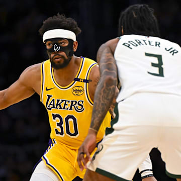 Mar 20, 2025; Los Angeles, California, USA; Los Angeles Lakers guard Jordan Goodwin (30) looks to pass against Milwaukee Bucks guard Kevin Porter Jr. (3) during the second half at Crypto.com Arena. Mandatory Credit: Jonathan Hui-Imagn Images