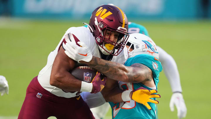 Aug 17, 2024; Miami Gardens, Florida, USA;  Washington Commanders running back Austin Ekeler (30) gains a few yards Miami Dolphins linebacker Curtis Bolton (58) closes in for the tackle during the first quarter at Hard Rock Stadium. Mandatory Credit: Jim Rassol-USA TODAY Sports