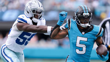 Oct 12, 2025; Charlotte, North Carolina, USA; Carolina Panthers running back Rico Dowdle (5) runs past Dallas Cowboys linebacker Kenneth Murray, Jr. (59) in the first quarter at Bank of America Stadium.
