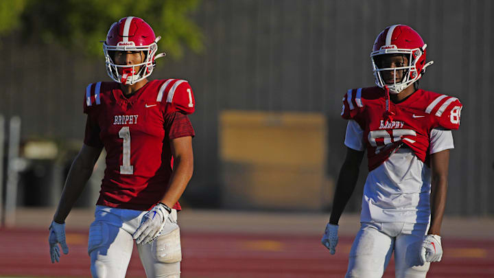 Brophy Prep wide receivers Devin Fitzgerald (1) and Donovan McNabb Jr. (85) listen to coaches during a practice at Brophy College Prepatory in Phoenix on Sept. 4, 2024.